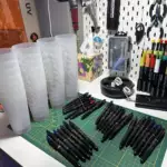 Stylos et gobelets personnalisés pour une crémaillère : 28 invités, 56 souvenirs